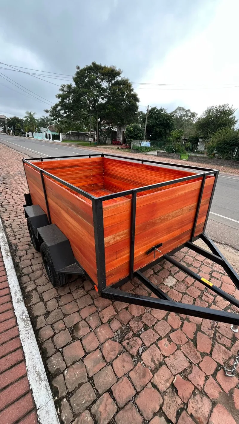 Carretinha de um eixo com laterais de madeira vista da traseira, na rua