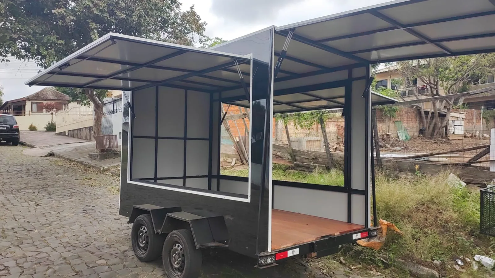 Reboque fechado com as laterais abertas em forma de toldo