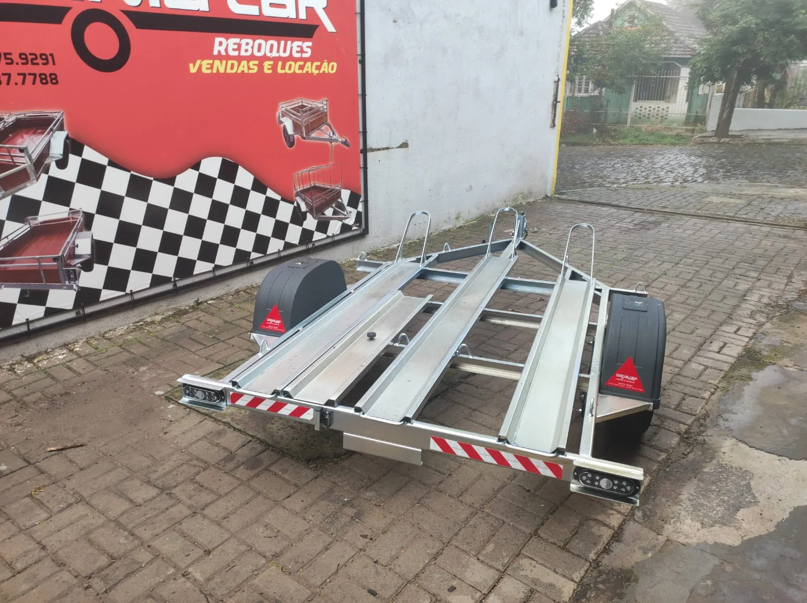 Reboque para transporte de motos com trilhos e suportes de roda