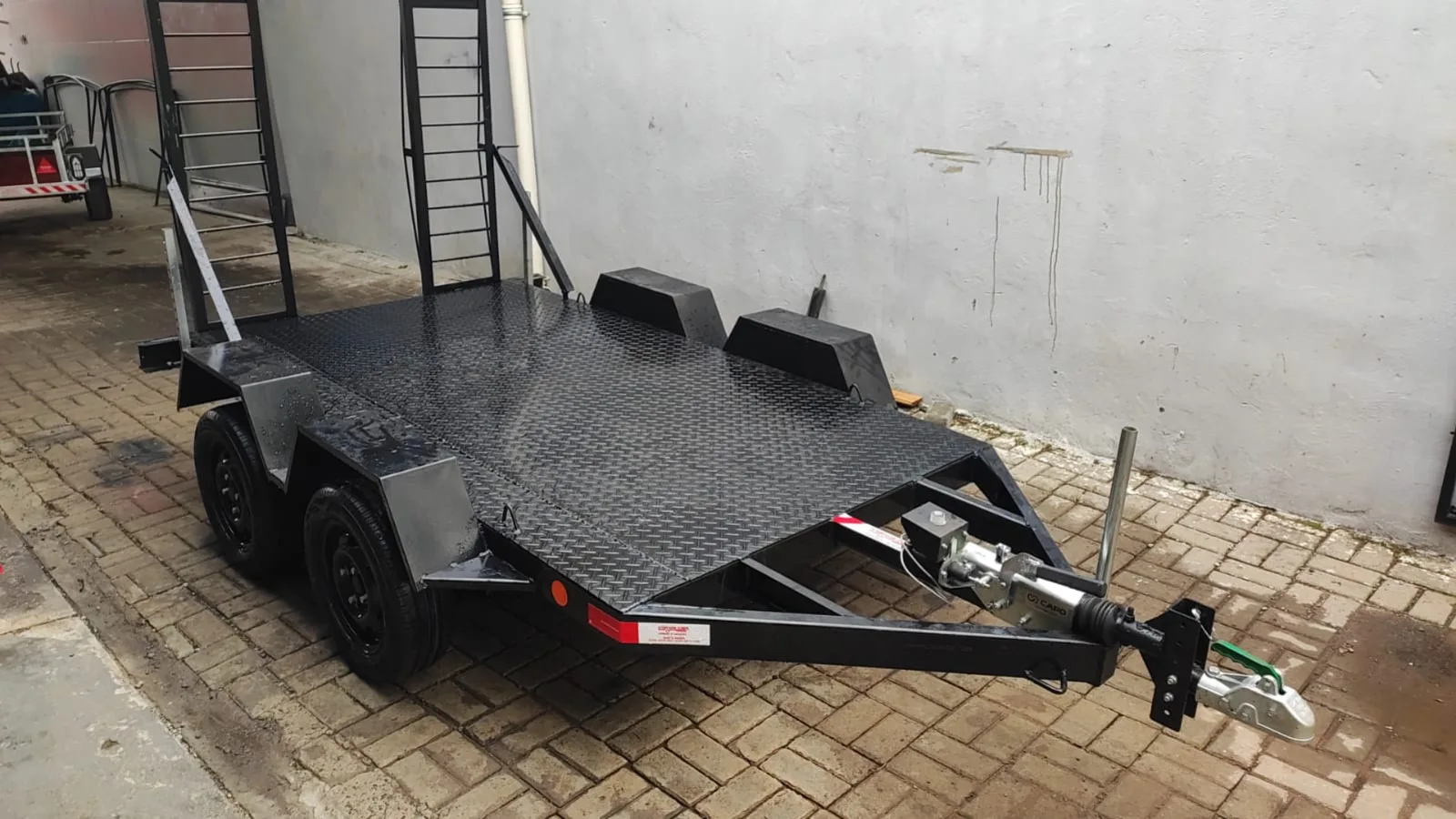 Plataforma de dois eixos para transporte de veículos com rampas levantadas
